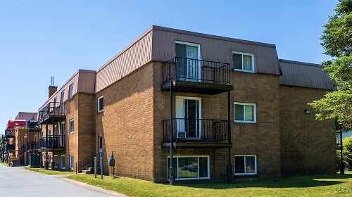 A red brick building with a balcony on the second floor.