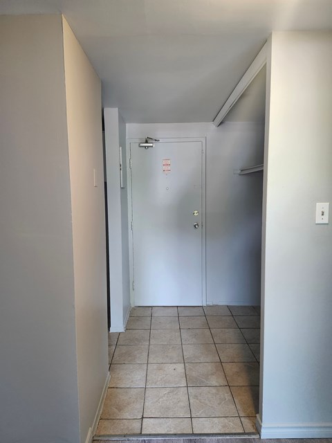 A white door with a glass window is in the middle of a hallway.