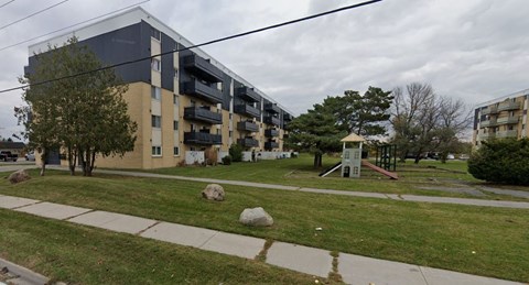 A grassy area in front of apartment buildings.