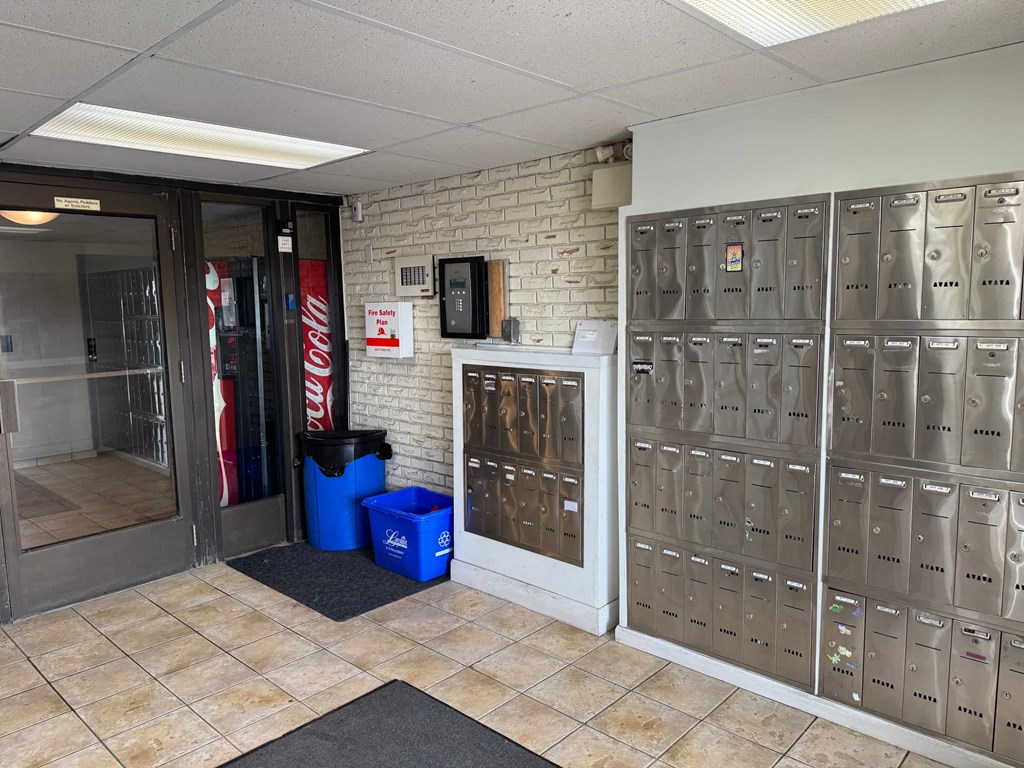 A wall of mailboxes is on the right side of a room.