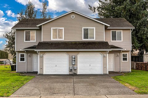 A two-story house with a garage and a driveway.