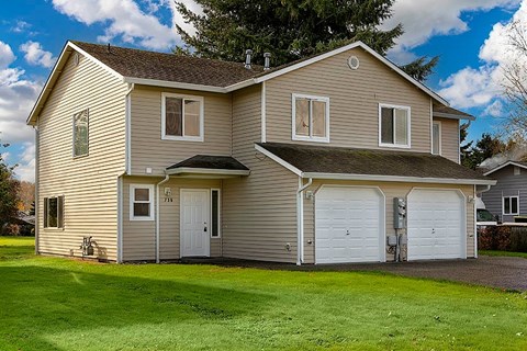 A house with a white garage door and a brown roof.