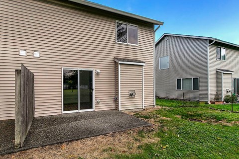 A house with a brown siding and a grey roof.