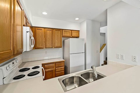 A kitchen with wooden cabinets and white appliances.