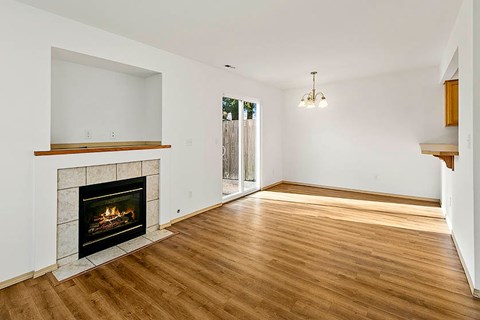 A living room with a fireplace and wood flooring.