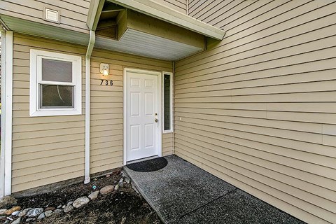 A small house with a white door and a window.