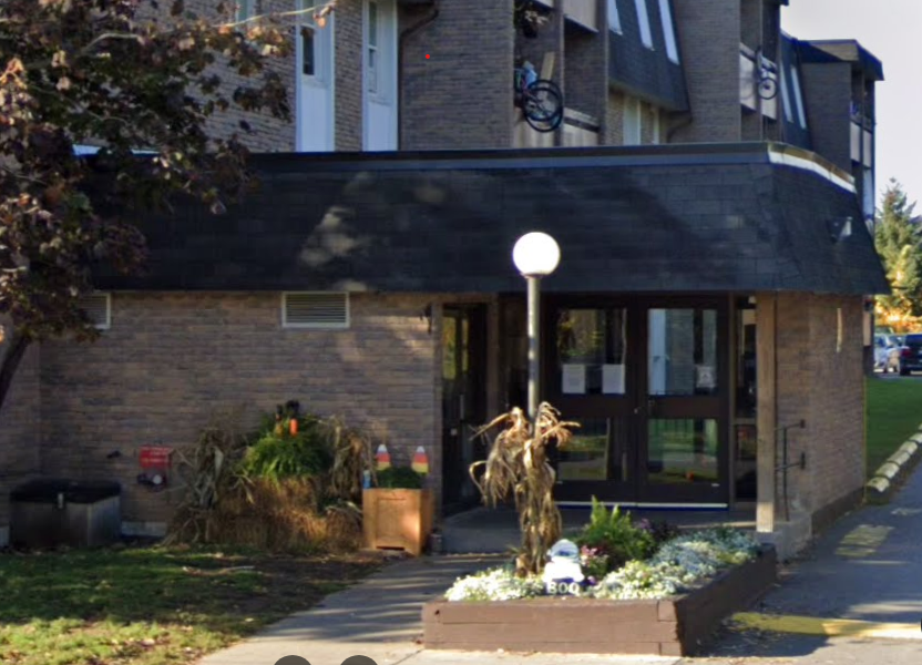 A building with a black awning and glass doors.