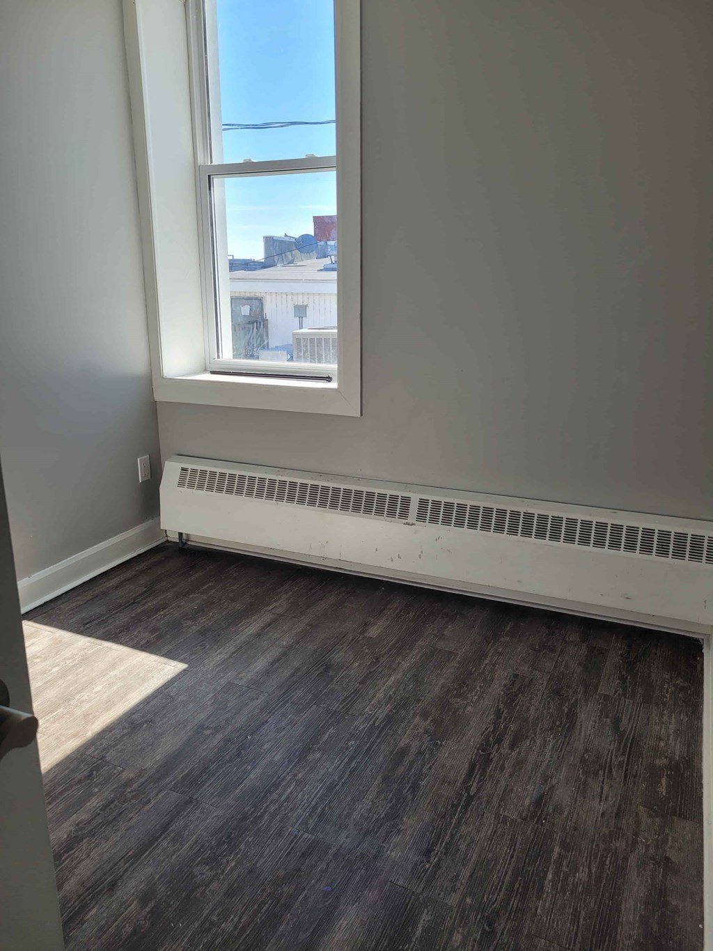 A room with a window and a radiator on the wall.