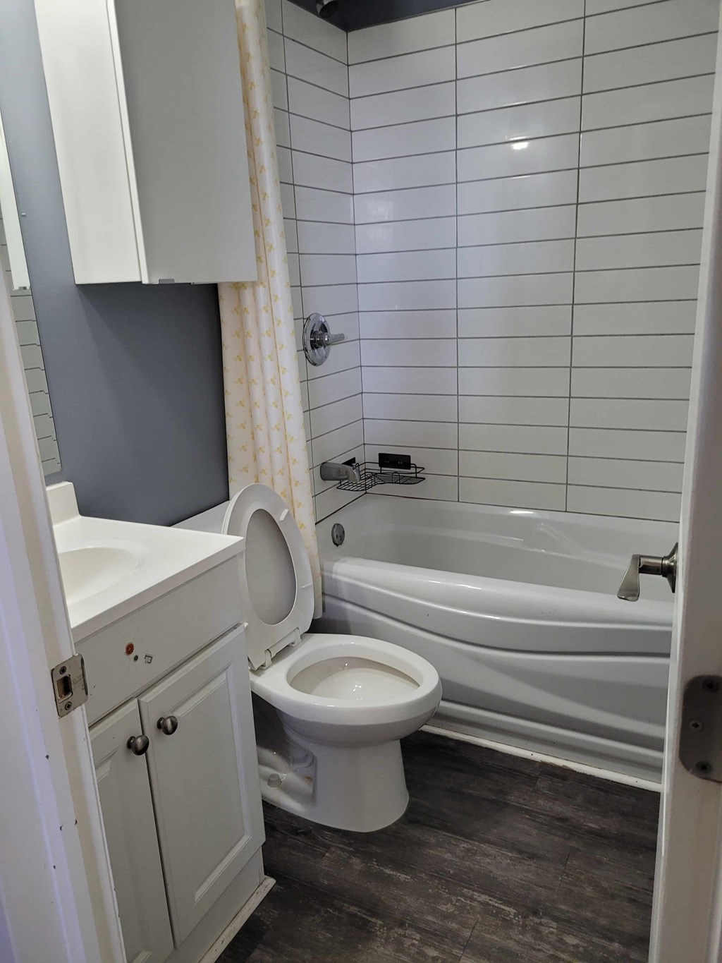 A white toilet sits in a bathroom next to a bathtub.