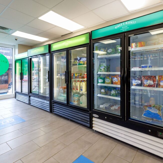 A row of refrigerators are lined up in a store.