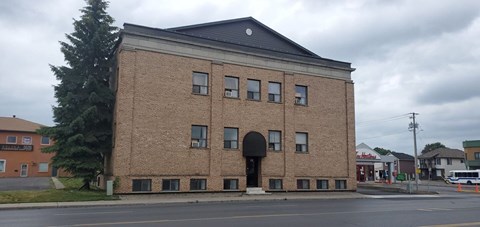 A large brick building with a black roof and a black door.