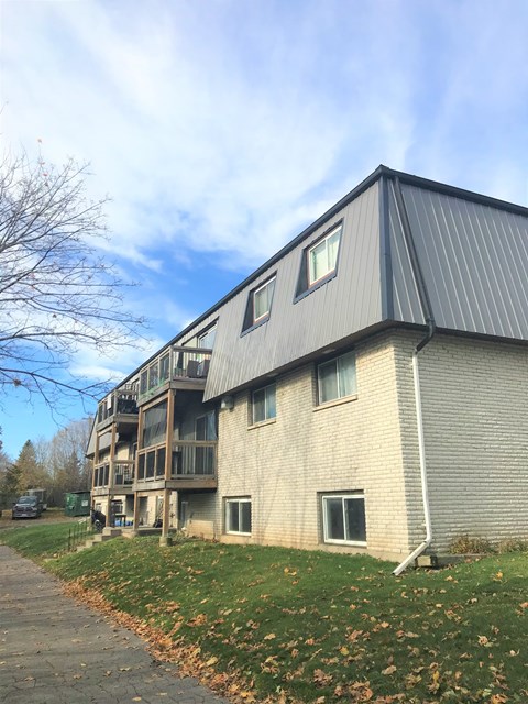 A building with a grey roof and a balcony.