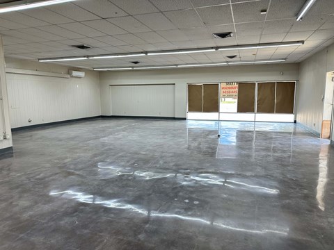 A large empty room with a sign on the wall.