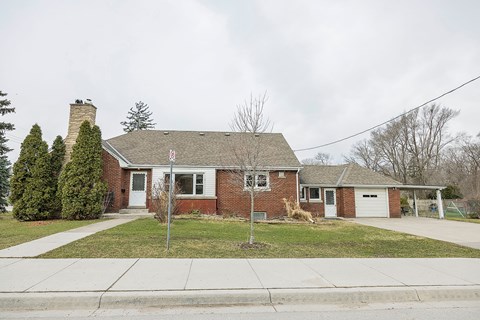 A red brick house with a white garage door.