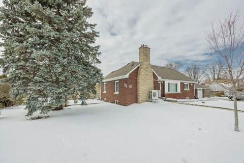 A house with a snow-covered front yard.