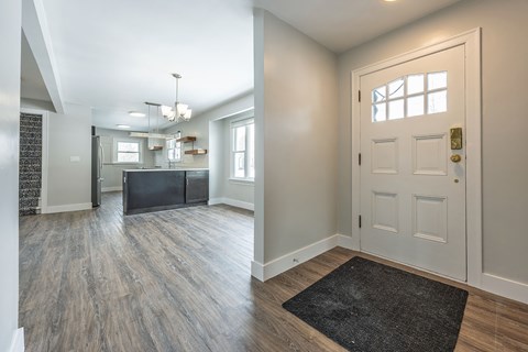 A kitchen with a black fridge and a white door.