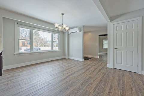 A room with a white door and a chandelier.