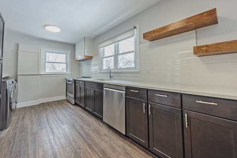 A kitchen with dark wood cabinets and stainless steel appliances.