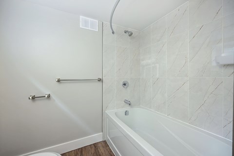 A white bathroom with a tub and shower.