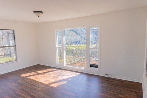 A room with a large window and sliding glass door.