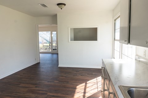 A kitchen with a wooden floor and a stainless steel sink.