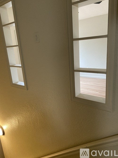 A wall with a window and a light switch.
