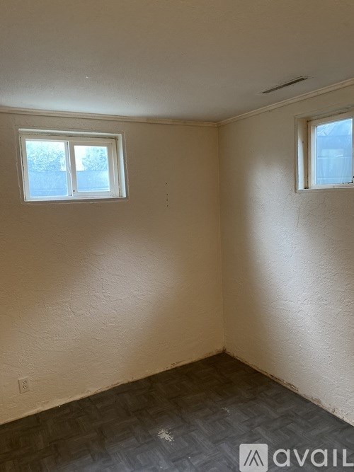 A room with a window and a wall with a light colored paint.