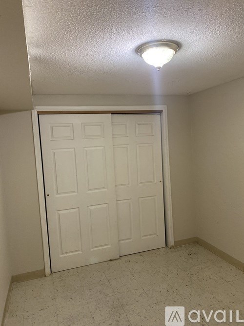 A white door in a room with a light on the ceiling.