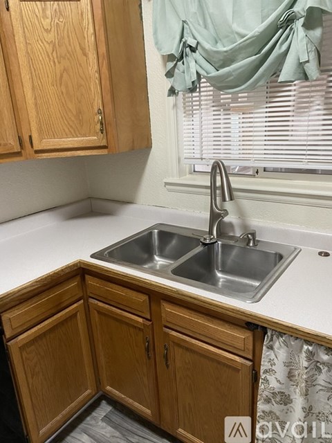 A kitchen with wooden cabinets and a double sink.