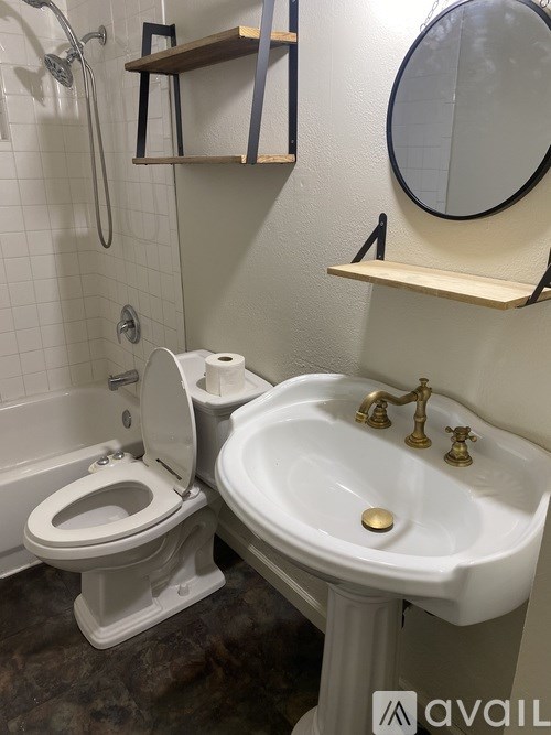 A bathroom with a toilet, sink, and mirror.