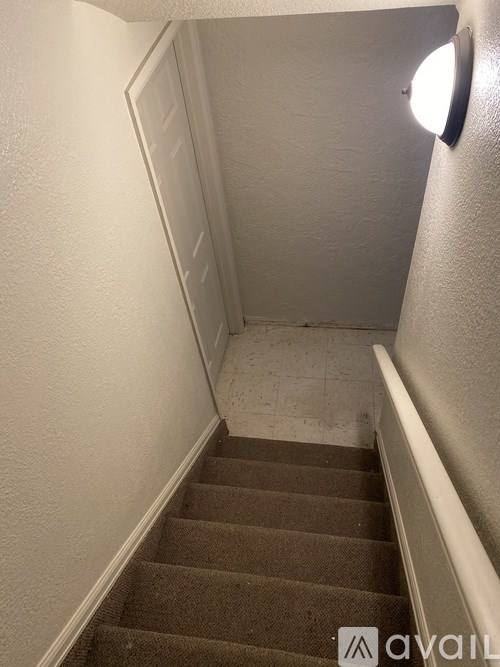 A staircase with a light on the wall.