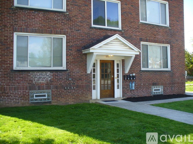 A brick house with a white door and windows.