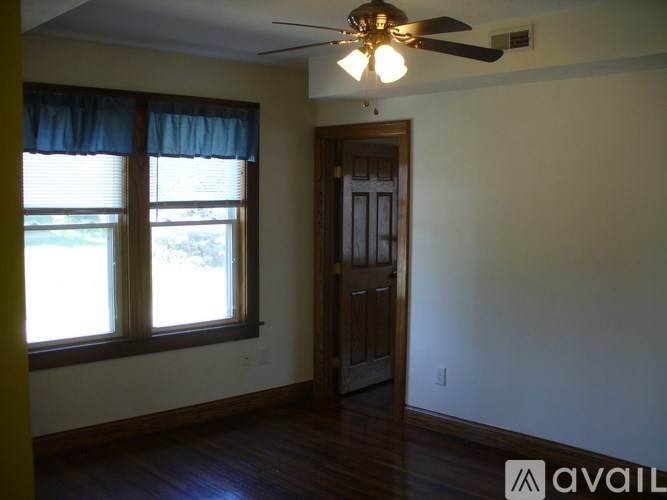 A room with a ceiling fan and a door.