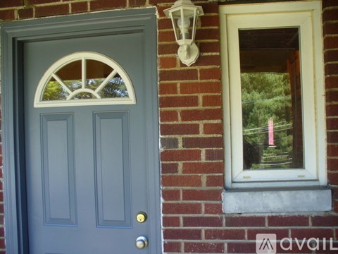 A grey door with a window on the wall.