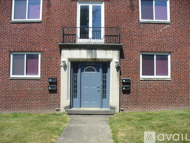 A red brick building with a blue door and windows.