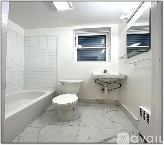 A white bathroom with a toilet, tub, and sink.