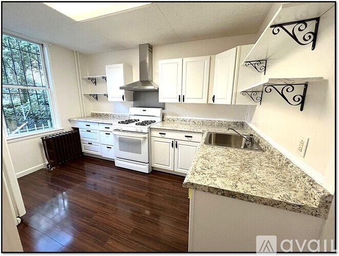 A kitchen with white cabinets and a granite countertop.