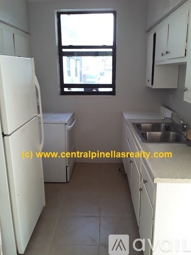 A small kitchen with white appliances and cabinets.