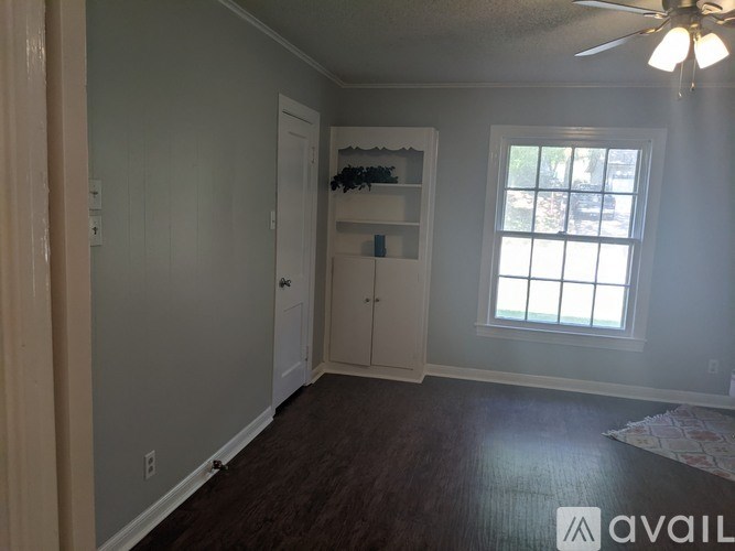 A room with a ceiling fan and a window.