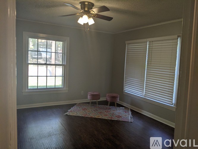 A room with a ceiling fan and a window with blinds.