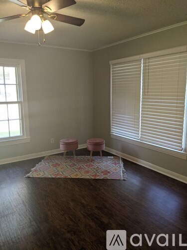 A room with a ceiling fan and a window with blinds.