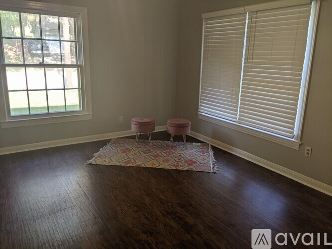 A room with a window and a rug on the floor.