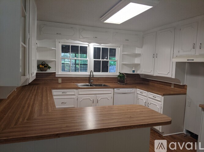 A kitchen with white cabinets and a wooden countertop.