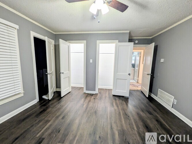 A room with a wooden floor and a white cabinet.