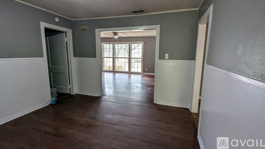 A room with wooden flooring and a door leading to a balcony.