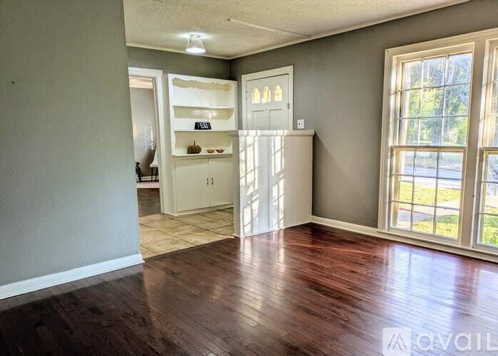 A room with a wooden floor and a white door.