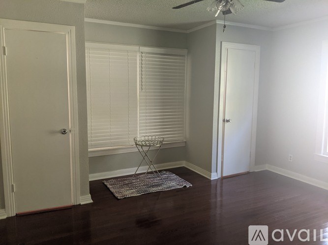 A room with a ceiling fan and a rug on the floor.