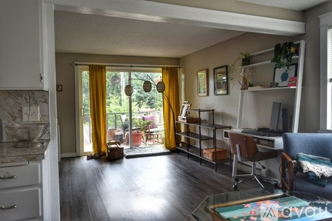A sunny living room with a glass table and a sofa.