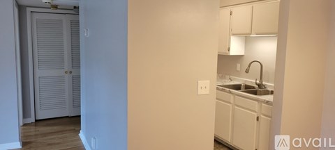 A kitchen with white cabinets and a sink.