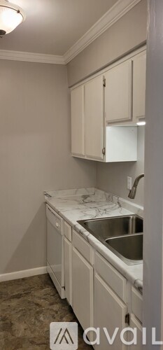 A kitchen with white cabinets and a marble countertop.